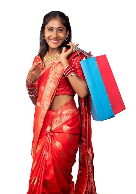 Beautiful Indian young girl holding and posing with shopping bags on a white background