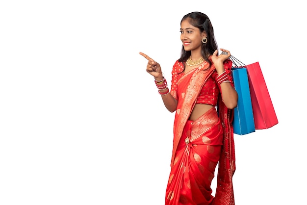 Beautiful Indian young girl holding and posing with shopping bags on a white background