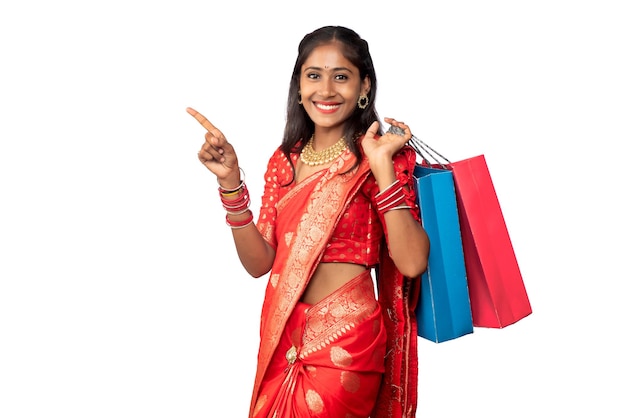 Beautiful Indian young girl holding and posing with shopping bags on a white background