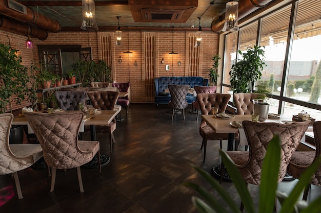 Beautiful interior of the restaurant in semiantique dark brown shades Served tables