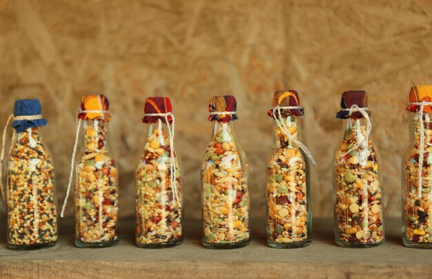 Beautiful jars with grains cereals legumes and seeds on wooden background