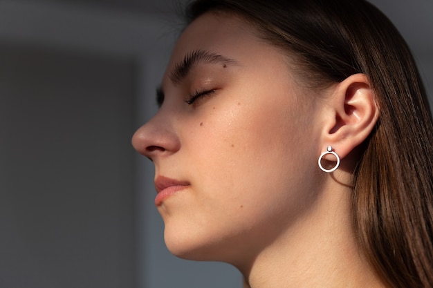 Beautiful jewelry model in modern silver round minimal earrings