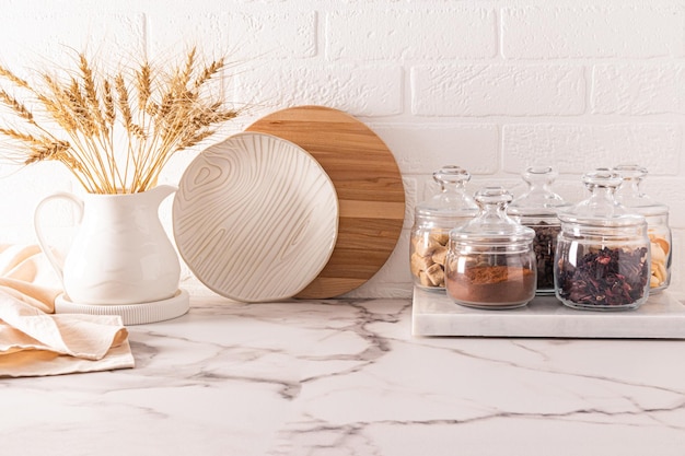 Beautiful kitchen background in light colors and a modern storage area in glass jars of various bulk products front view eco tableware