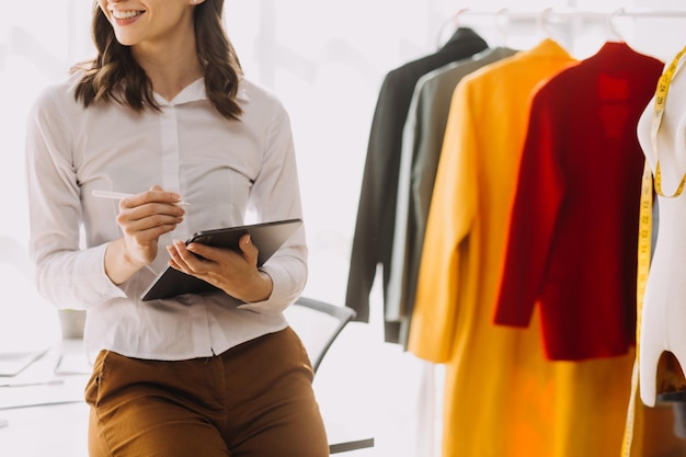 Beautiful lady blogger showing clothes in front of the camera to recording vlog video live streaming at her shop Online Shopping Cart notion