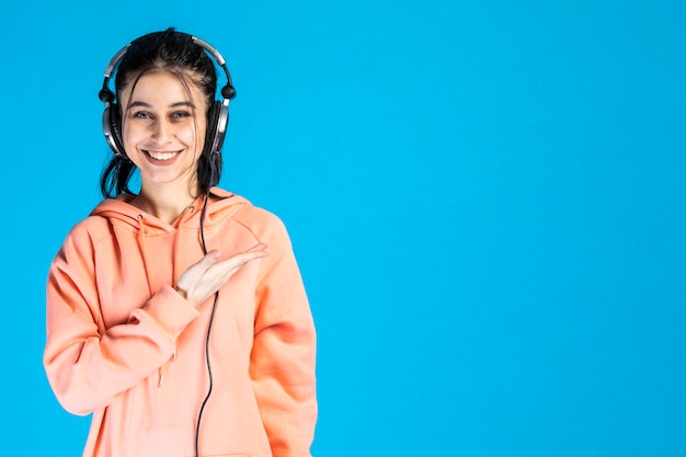 A beautiful lady smiling and wearing headphones on blue background