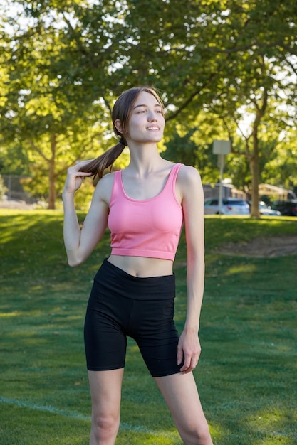 Beautiful lady standing at the park and looking to the camera