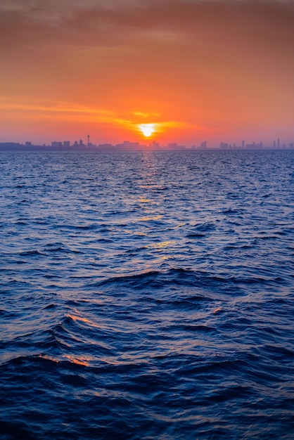 Beautiful landscape of blue sea with skyline city background at sunrise