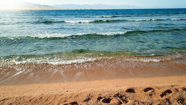 Beautiful landscape of calm sea waves rolling and braking on the sandy sea beach