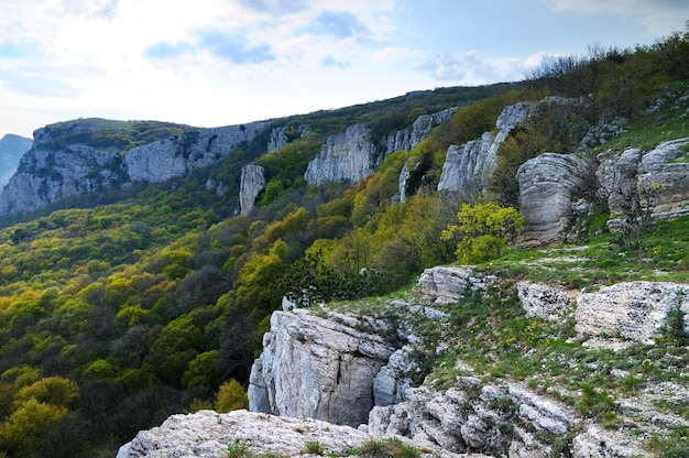 Beautiful landscape in Crimea, view from top of Ai-Petri mountain, forest valley and white clouds in sky