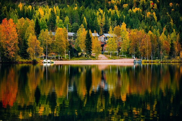 Beautiful landscape of fall colors forest reflected in the still waters of a calm lake in Finland