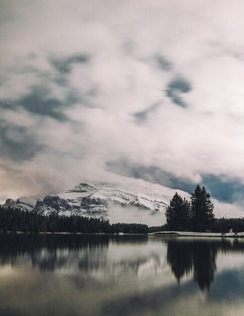 Beautiful landscape of hills covered in snow with the reflection on a lake