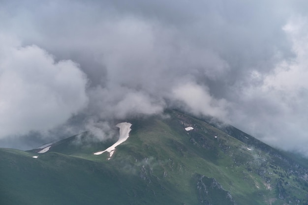 Beautiful landscape of National Park of Russia Dark thundercloud envelops snowy mountain peak