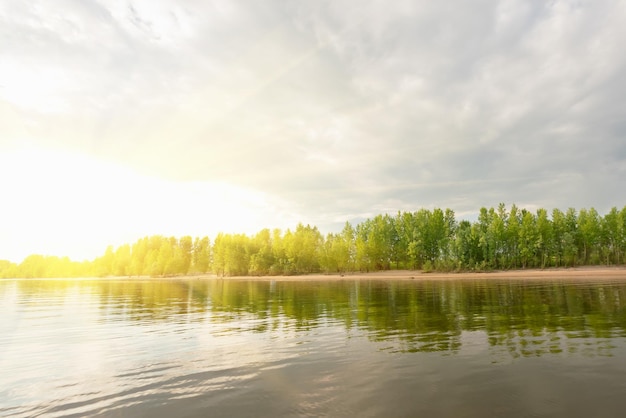 Beautiful landscape river sky with clouds and sandy beach with green trees sunny