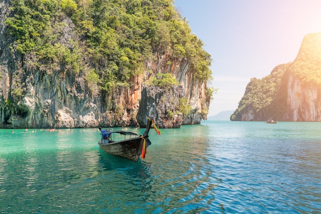 Beautiful landscape of rocks mountain and crystal clear sea with longtail boat at Phuket, Thailand.