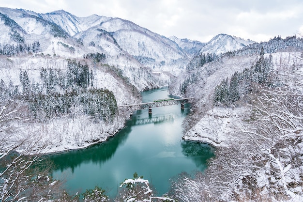 Beautiful landscape of Tadami line train across Tadami river in winter at Fukushima