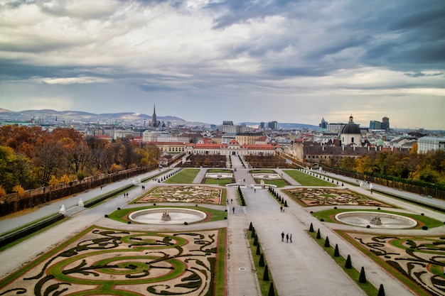 Photo beautiful landscape with baroque palace ensemble schloss belvedere and garden parterre with regular planting of plants and flowers in vienna, austria on a background of cloudy sky.