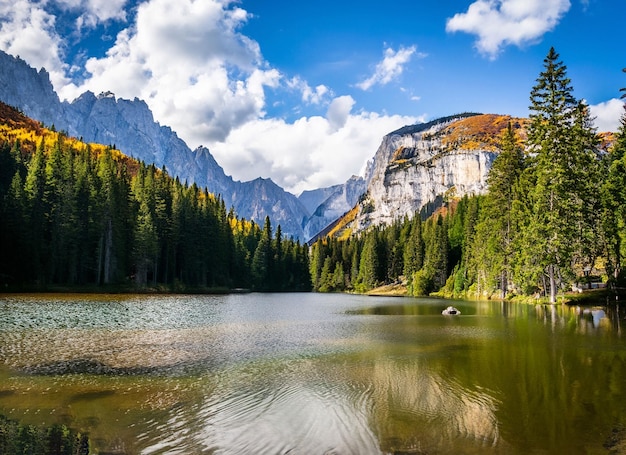 Beautiful landscape with a lake in a forest and amazing high rocky mountain