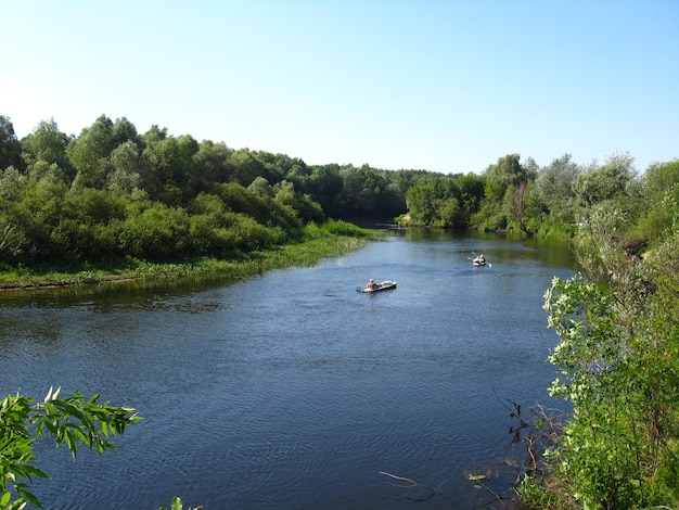 Beautiful landscape with river and canoe with people on it