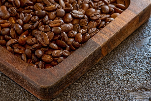 Beautiful large roasted beans of aromatic coffee on a wooden board Soft selective focus