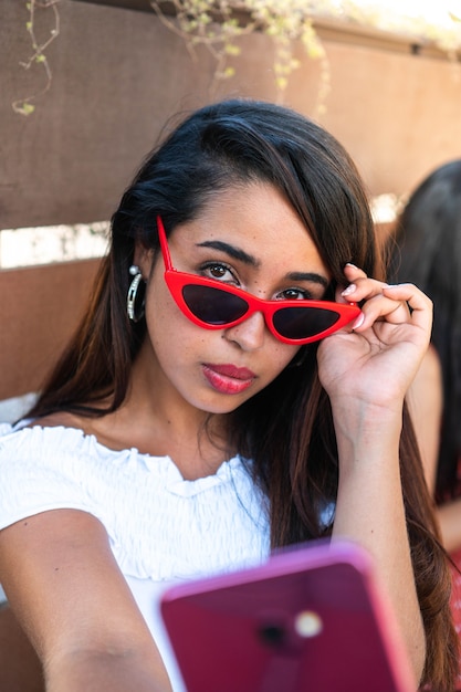 Beautiful latin girl taking a selfie Hispanic woman taking a picture for her social media