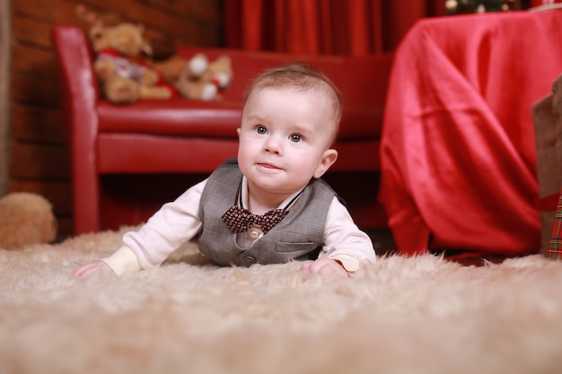 Beautiful little baby boy celebrates Christmas. New Year's holidays. Baby with gift.