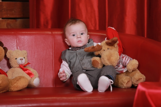 Beautiful little baby boy celebrates Christmas. New Year's holidays. Baby with gift.