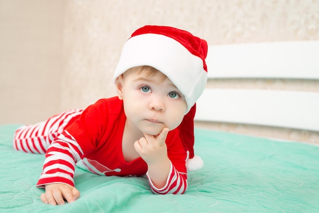 Beautiful little baby boy lies on his tummy and looking up ridiculously propping up his head with