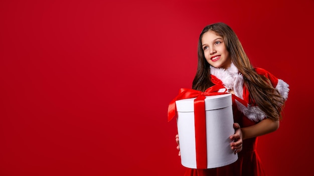 Beautiful little girl in festive costume hold gift box christmas decoration holiday fun