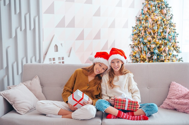 Beautiful little girls with gifts on Christmas in the living room