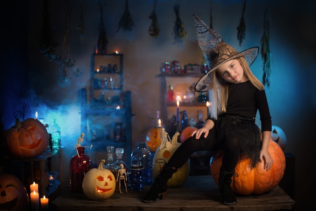 Beautiful little witch with Halloween decorations