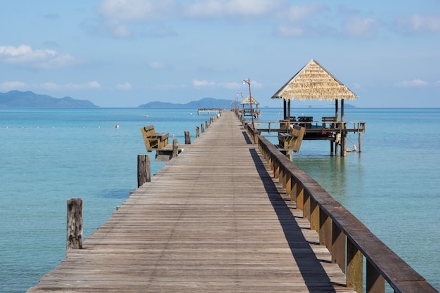 Beautiful long wood bridge with a hut at Kohmak Island in Thailand.