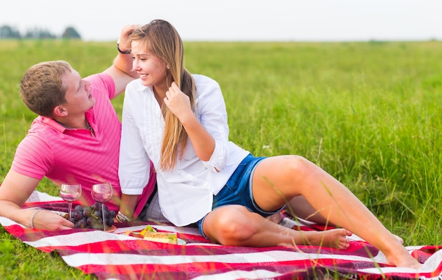 Beautiful love couple having romantic picnic outdoors on summer sunny day.