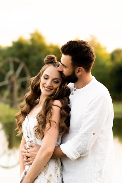 Beautiful man and woman on a lake background on a sunny day