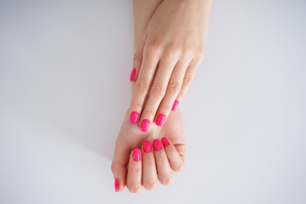 Beautiful manicure on a white background. Beautiful female hands. Beauty and skin care concept, flat lay.