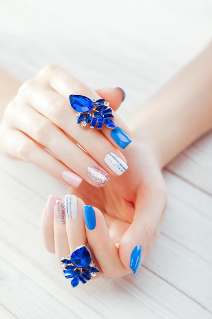 Beautiful manicure with earrings combination of blue white pink colors female nail decor