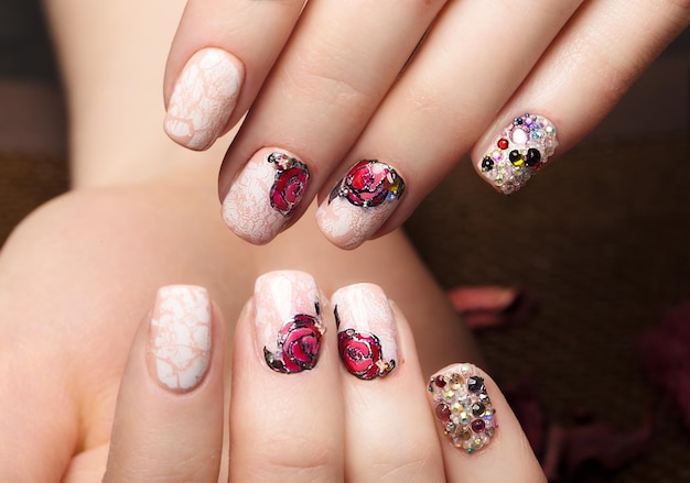 Beautiful manicure with flowers on female fingers Nails design Closeup Picture taken in the studio on a white background