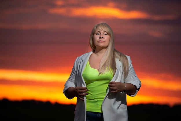 Beautiful middle age blond woman against sunset sky