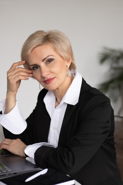 beautiful middle aged woman dressed in business clothes at the table