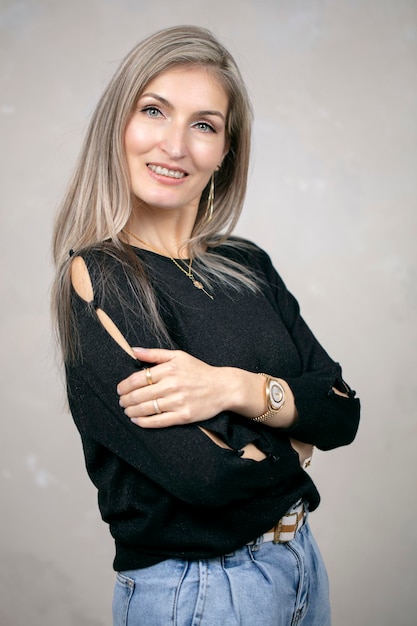 A beautiful middleaged woman with long hair in a black sweater