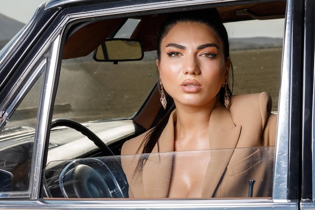 Beautiful model sitting on driver seat and looking at the camera High quality photo