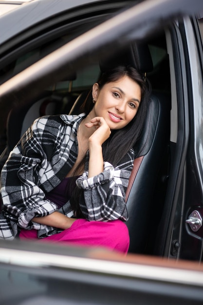 Beautiful modern young woman in her car The driver automobile Vacation trip Lifestyle