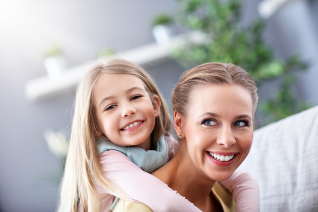 beautiful mom and her daughter having fun at home