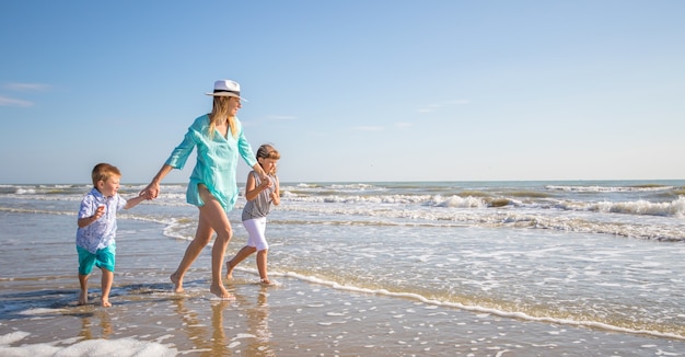 Beautiful mom play with her children in the sea