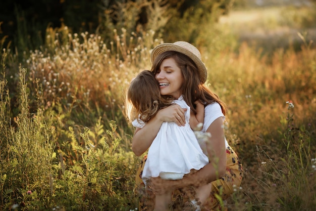 Beautiful mother and daughter playing in the field