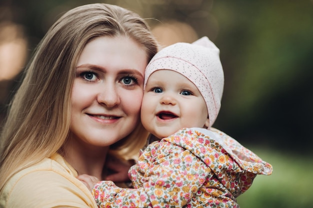 Beautiful mother and daughter walking in the park in autumn portrait mom and daughter family concept