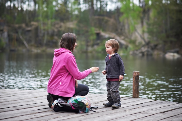 Beautiful mother and her cute son walking in the park