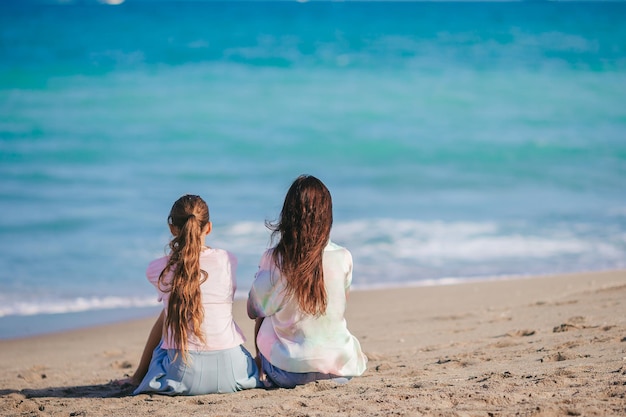 Beautiful mother and her teen daughter on the beach