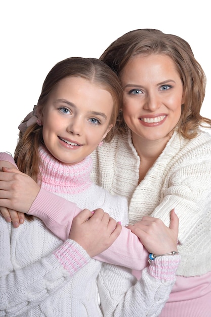 Beautiful mother hugs her daughter on a white background