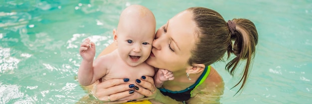 Beautiful mother teaching cute baby girl how to swim in a swimming pool child having fun in water