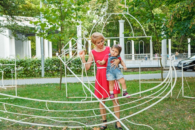 Beautiful mother with her daughter in the park in summer